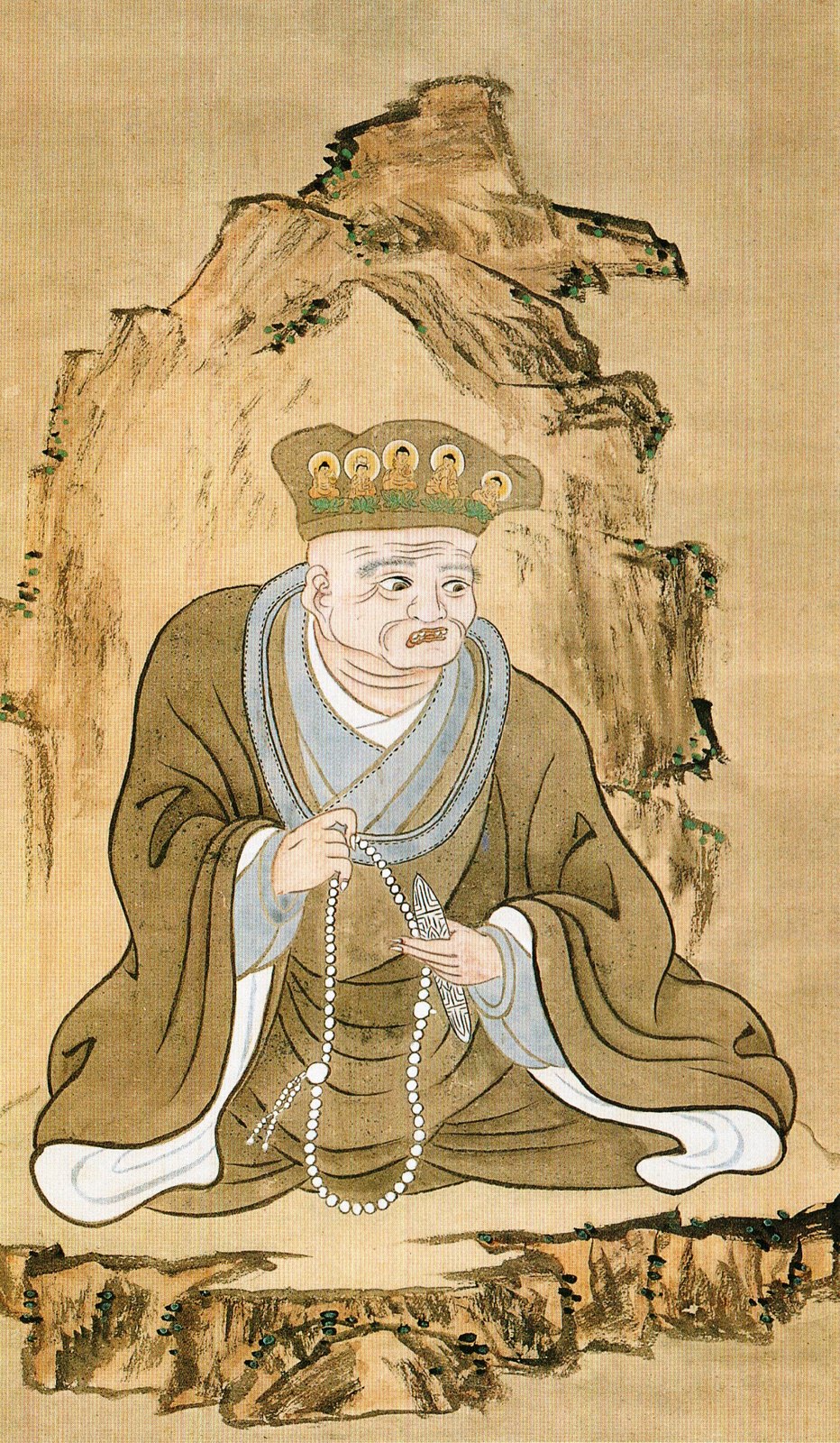 Enkū as painted by Ōmori Kyokutei in 1805, 110 years after his death: a cap bearing five Buddhas, prayer beads and a blade in his hands.